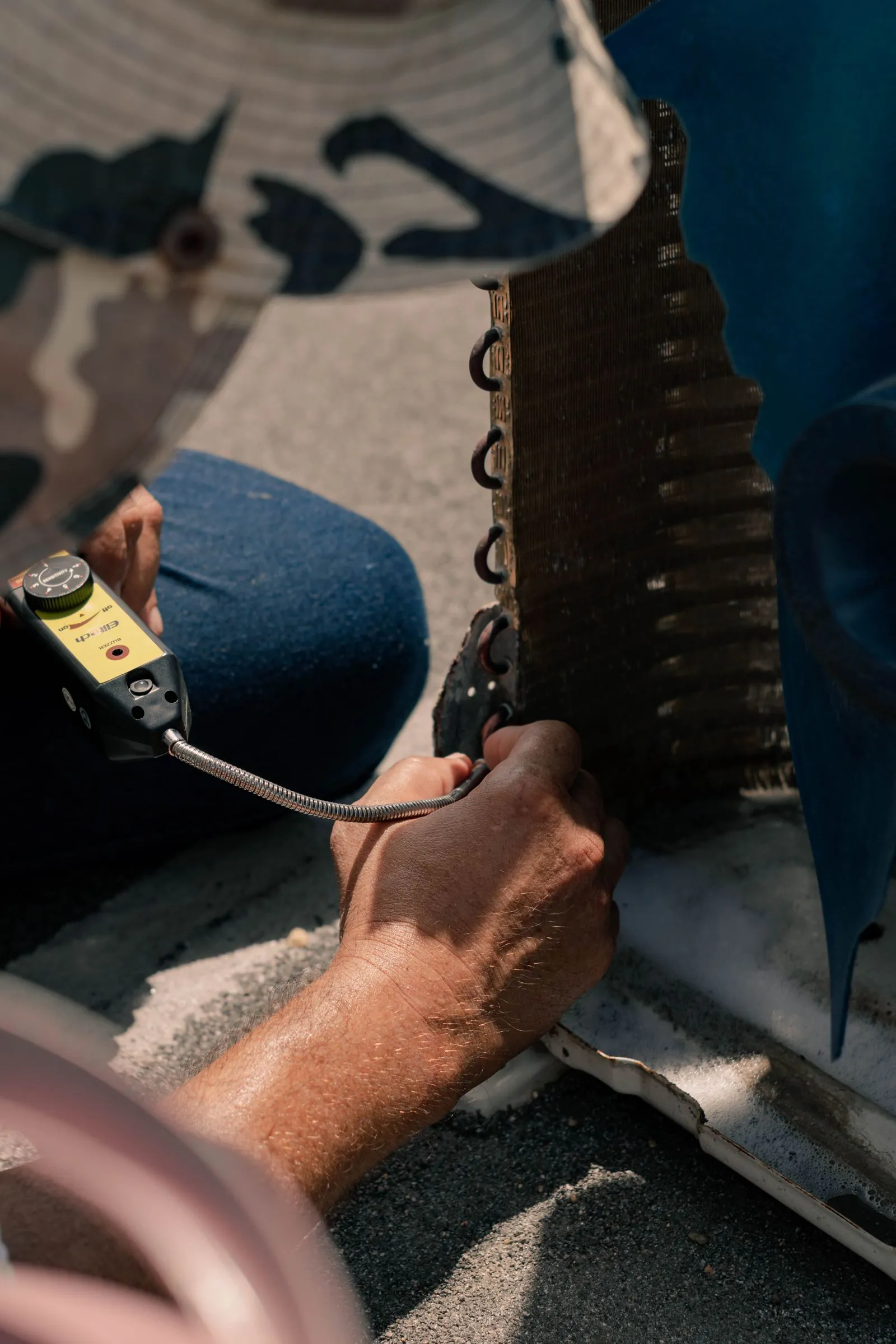 Facility maintenance technician servicing equipment with hand tools